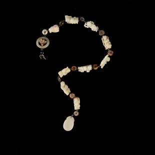 A Chinese necklace with various jade boy carvings, Ming or Qing dynasty: A Chinese necklace with various jade boy carvings Ming or Qing dynasty A single strand necklace comprising eleven pale-green jade carvings alternated with small bi; jades featuring boy motifs, a pierc